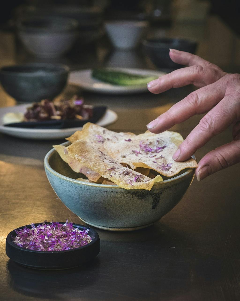 Tynde chips med blomster og fermenteret creme fraiche hos cocktailbaren 1408 til 65 kr.