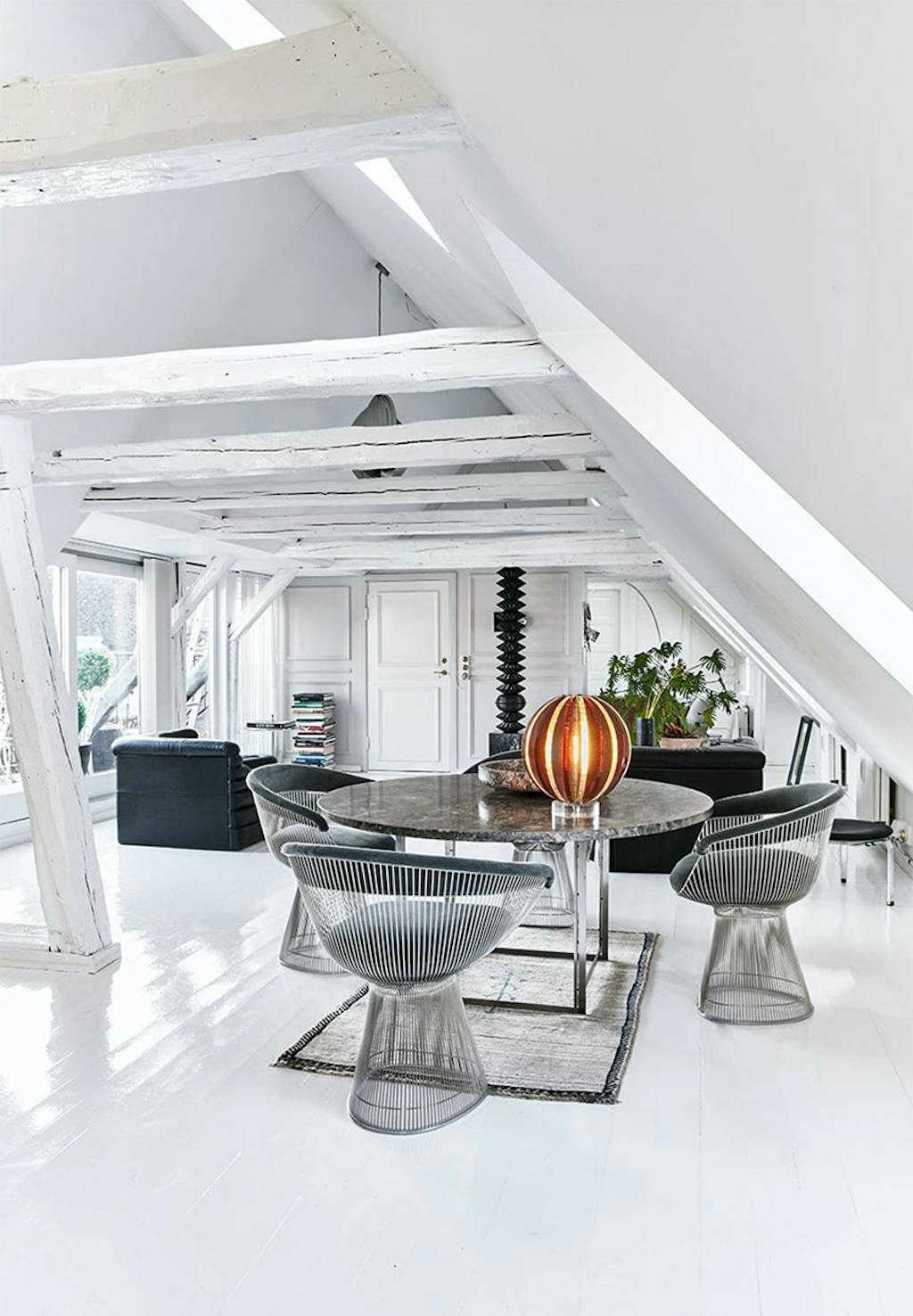 En intim spiseplads med et rundt marmorbord og blød belysning fra bordlampen