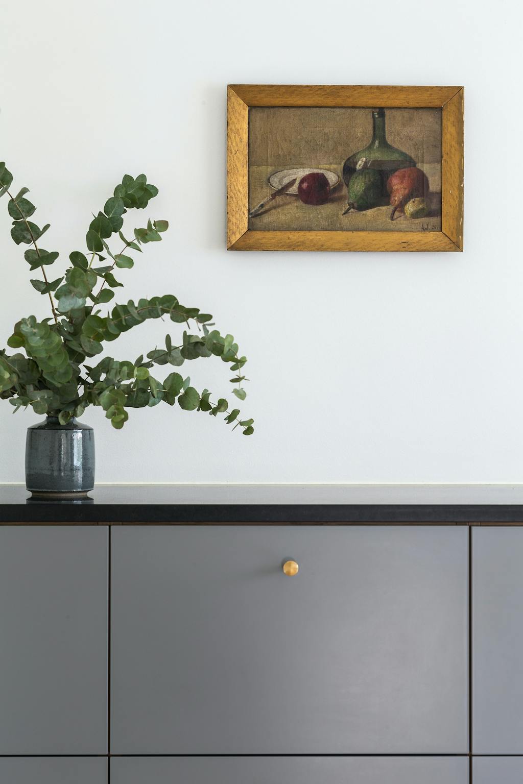 Vase på køkkenbord og maleri på væggen