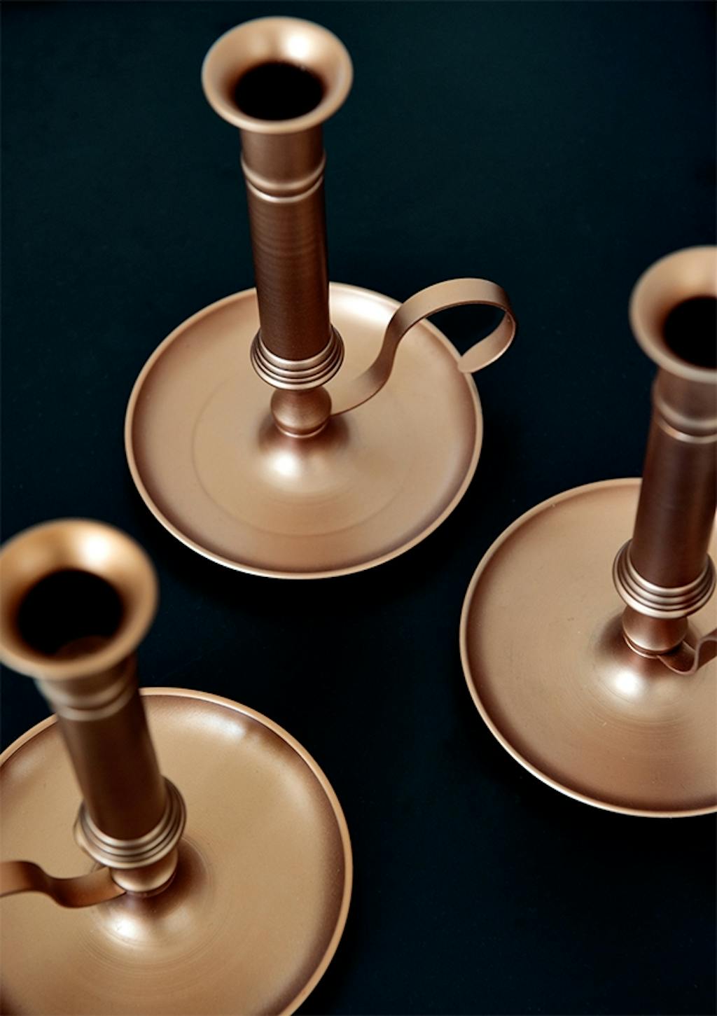 messing lysestager på sort bord