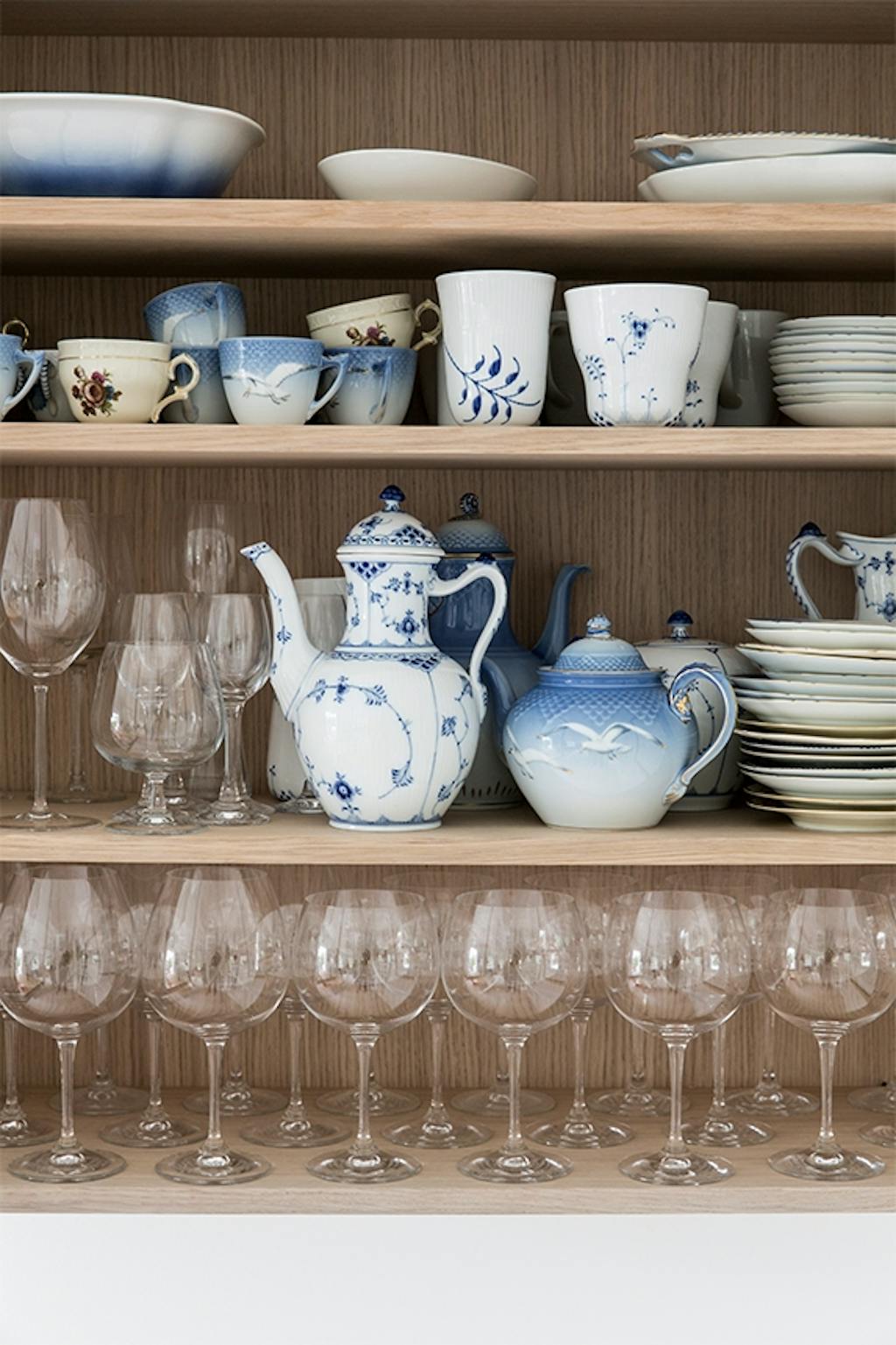 hylder med procelæn og vinglas