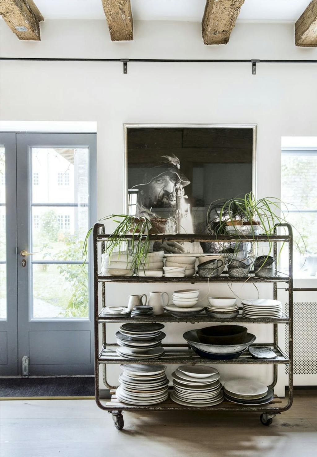 køkken med stort fotografi på væggen og en gammel rullevogn