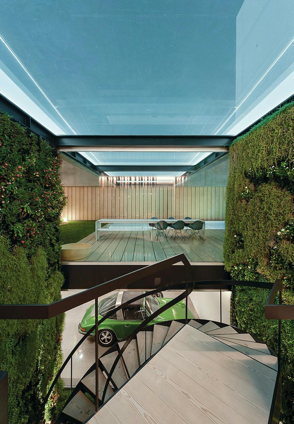 Kig fra vindeltrappe til terrasse med bord og bænkesæt og swimmingpool