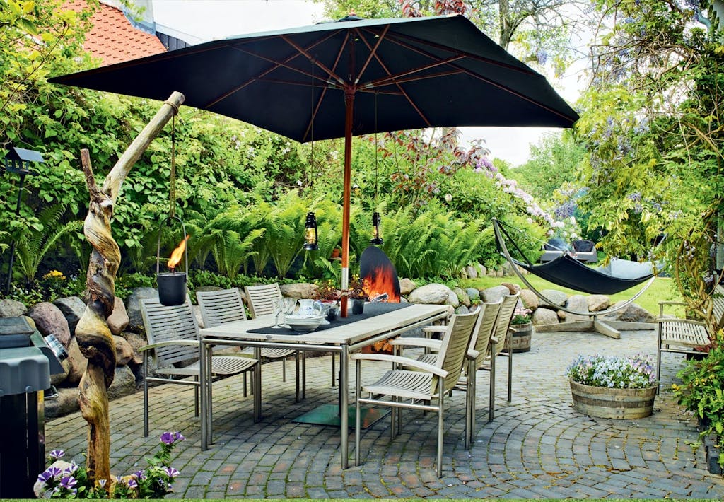 Aftenterrasse omkranset af magnolie- og hyldetræer