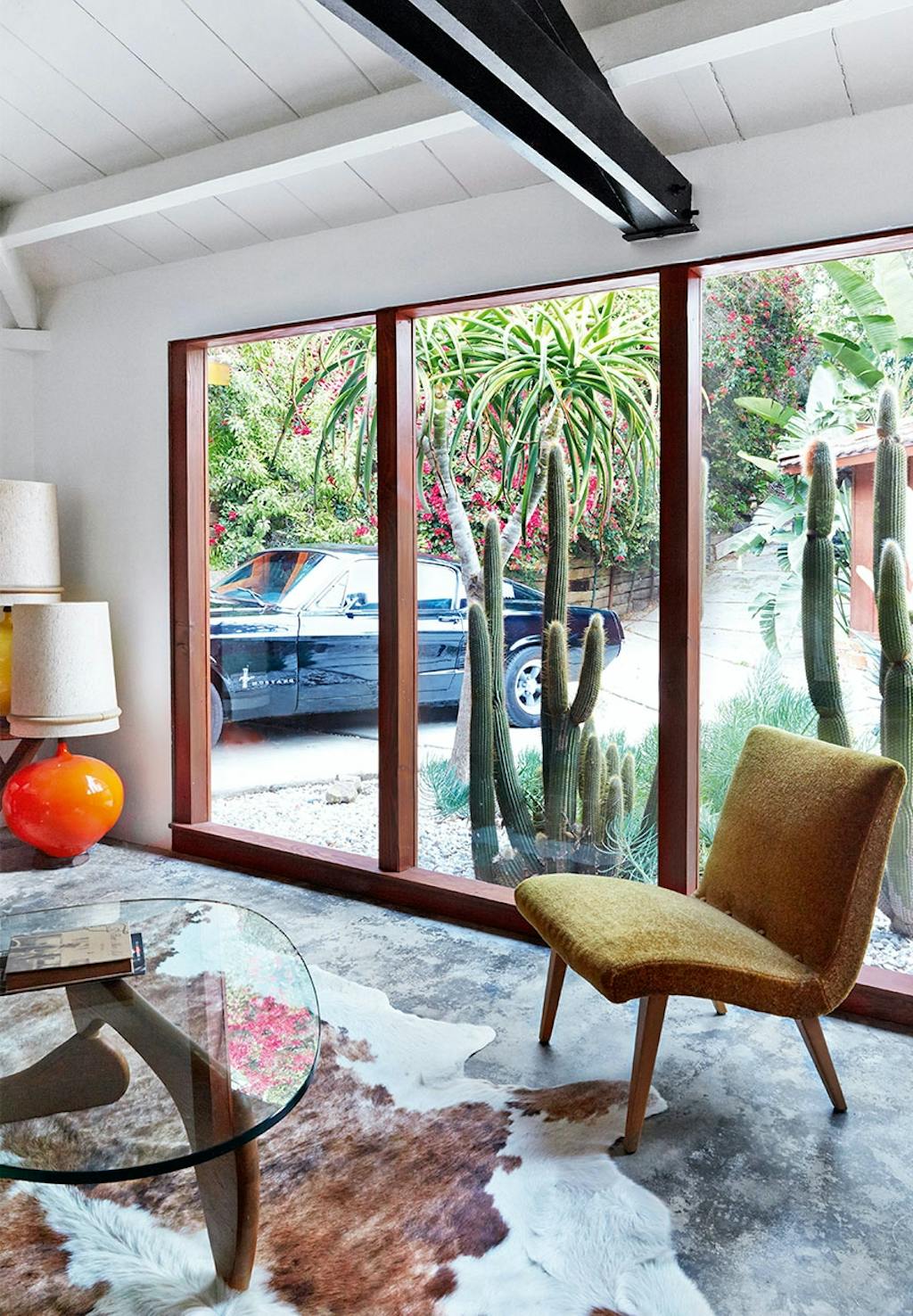 Vintage stol stående foran vindue med brunt og hvidt koskind liggende på gulvet