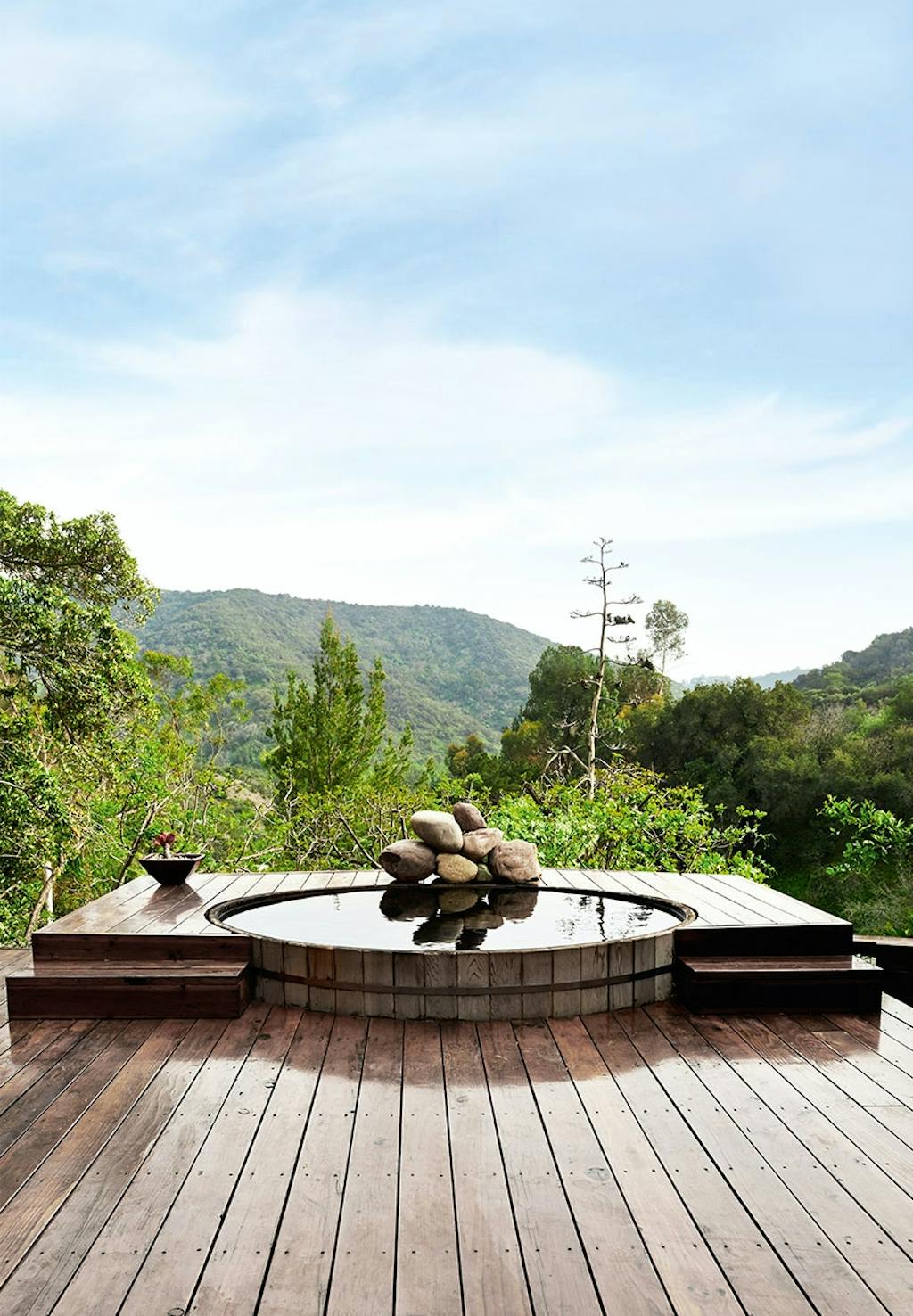Udendørs boblebad bygget ned i træterrassen med skøn udsigt over natur