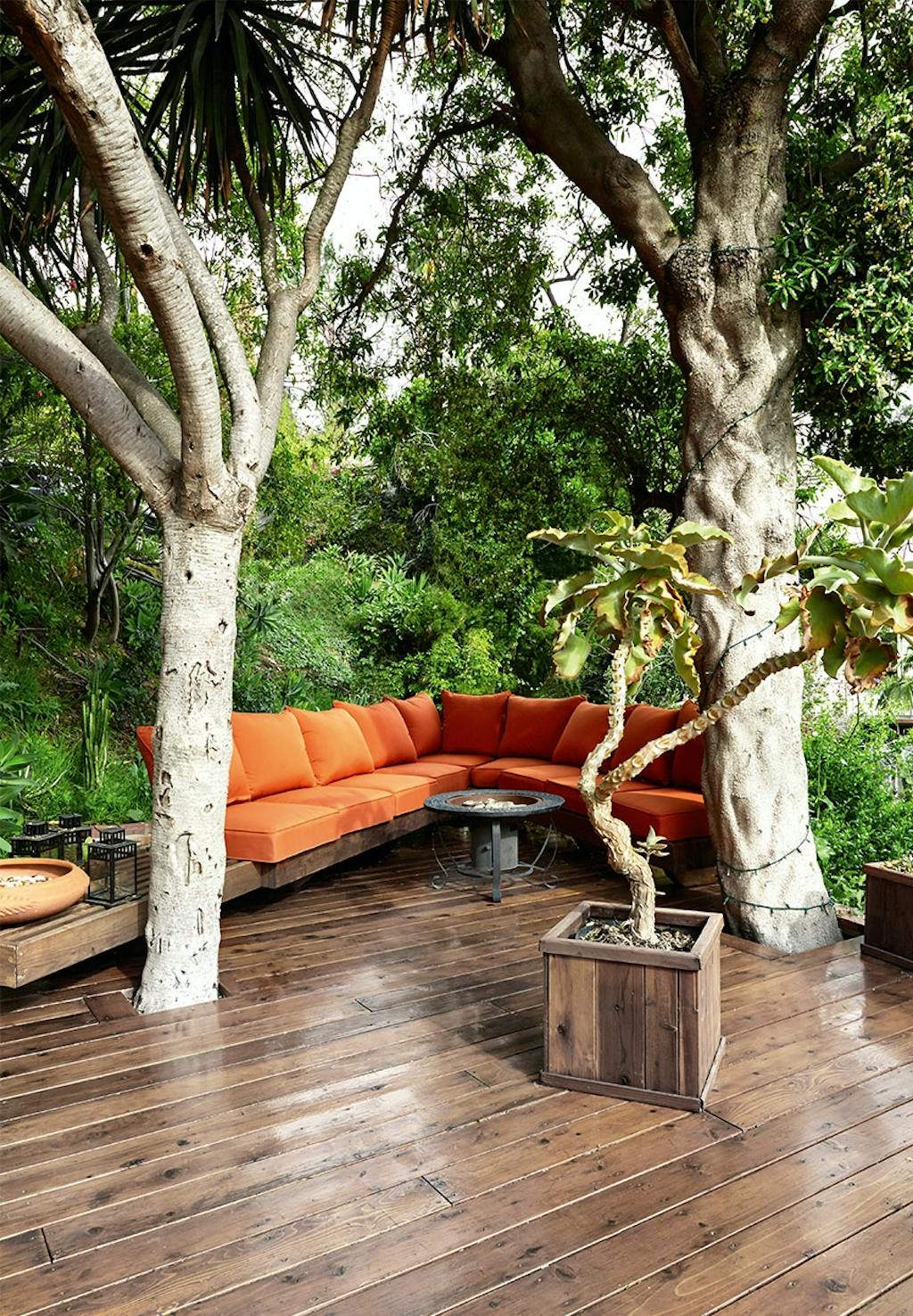 Lounge-område på træterrassen med specialbygget sofa med orange hynder og puder