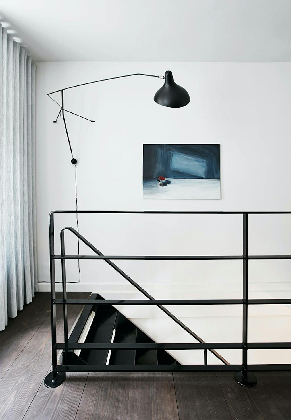 Trappe med sort gelænder til førstesal med mørkebrune gulve