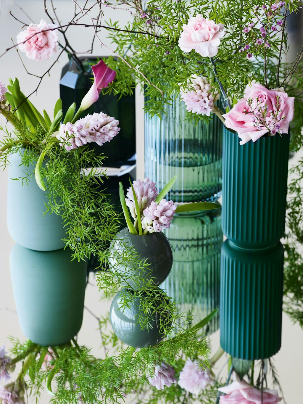 Grønne vaser med lyserøde blomster