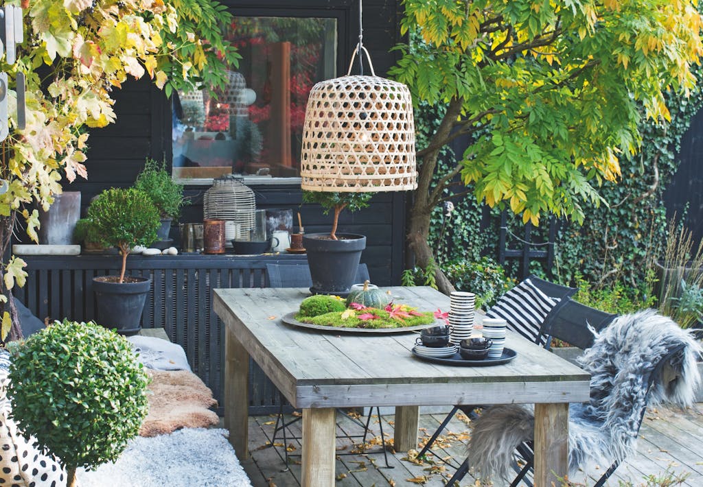 efterårshave med terrasse med bord og plaider og stole
