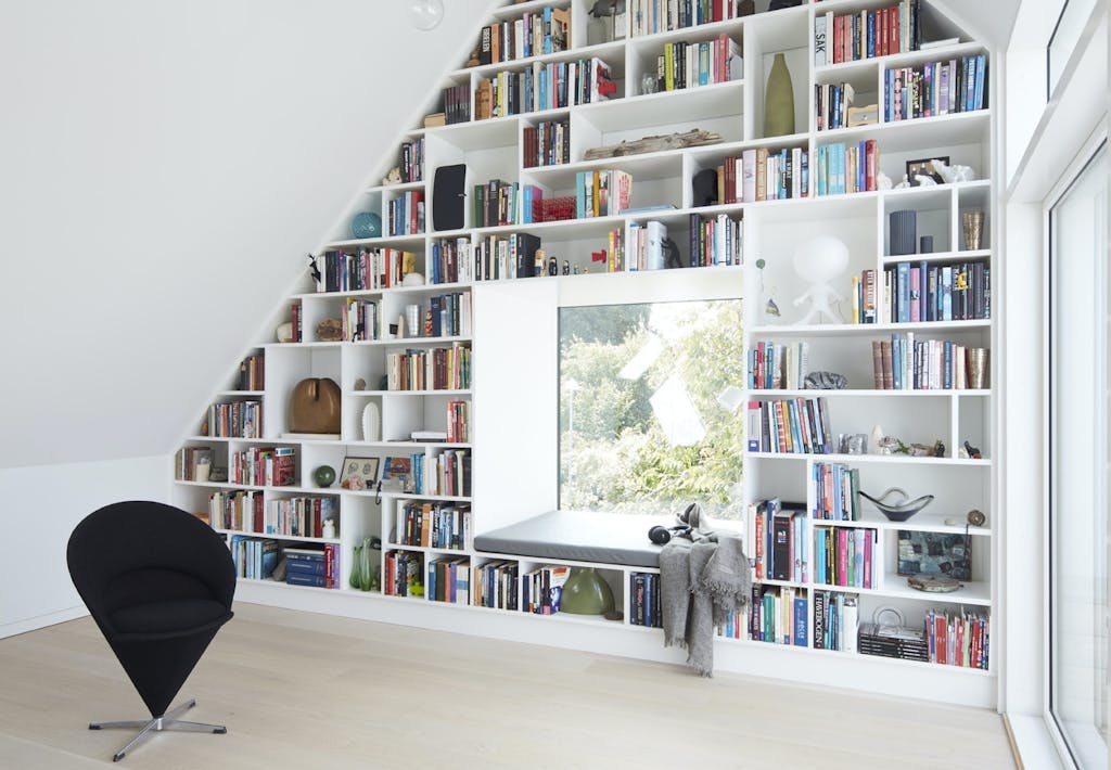 bogreol fra gulv til loft med vindue i midten