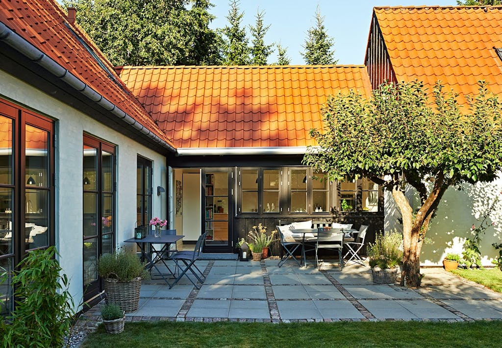 Skøn terrasse foran den tilbyggede mellemgang mellem hovedhuset og tilbygningen