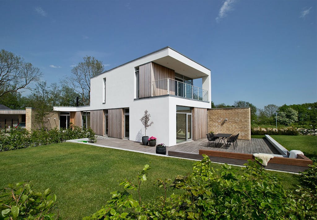 Facade af miks af tegl, cedertræ og hvidt facadepuds på begge etager