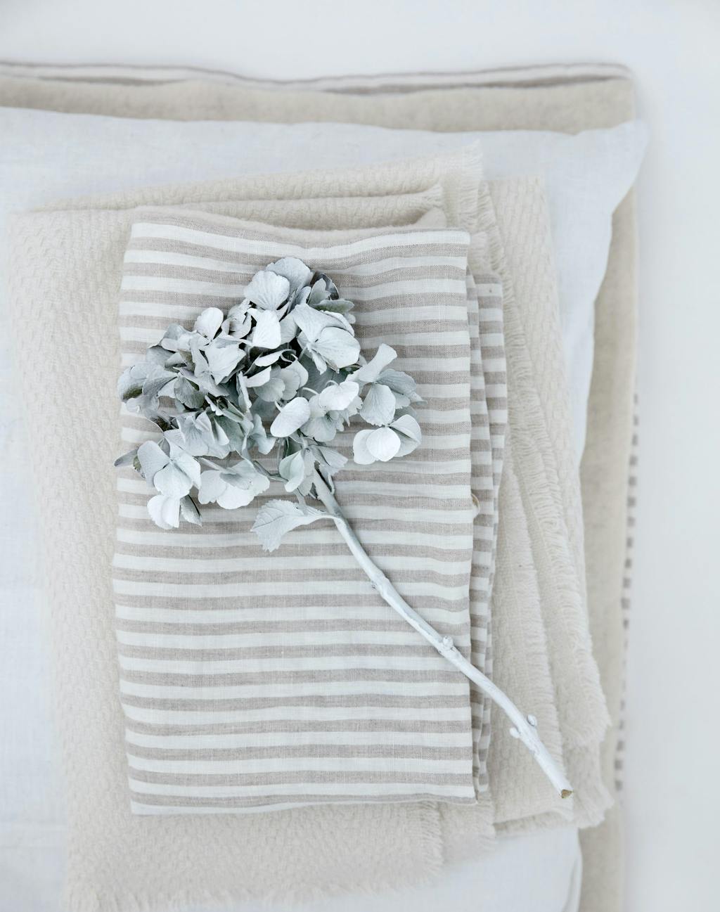 Strikkede tæpper med vissen hortensia som pynt på toppen