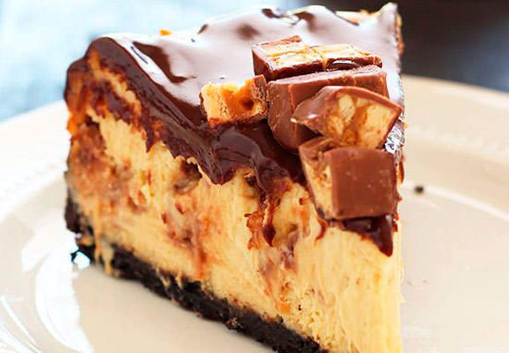Et stykke Snickers-cheesecake med Oreo bund