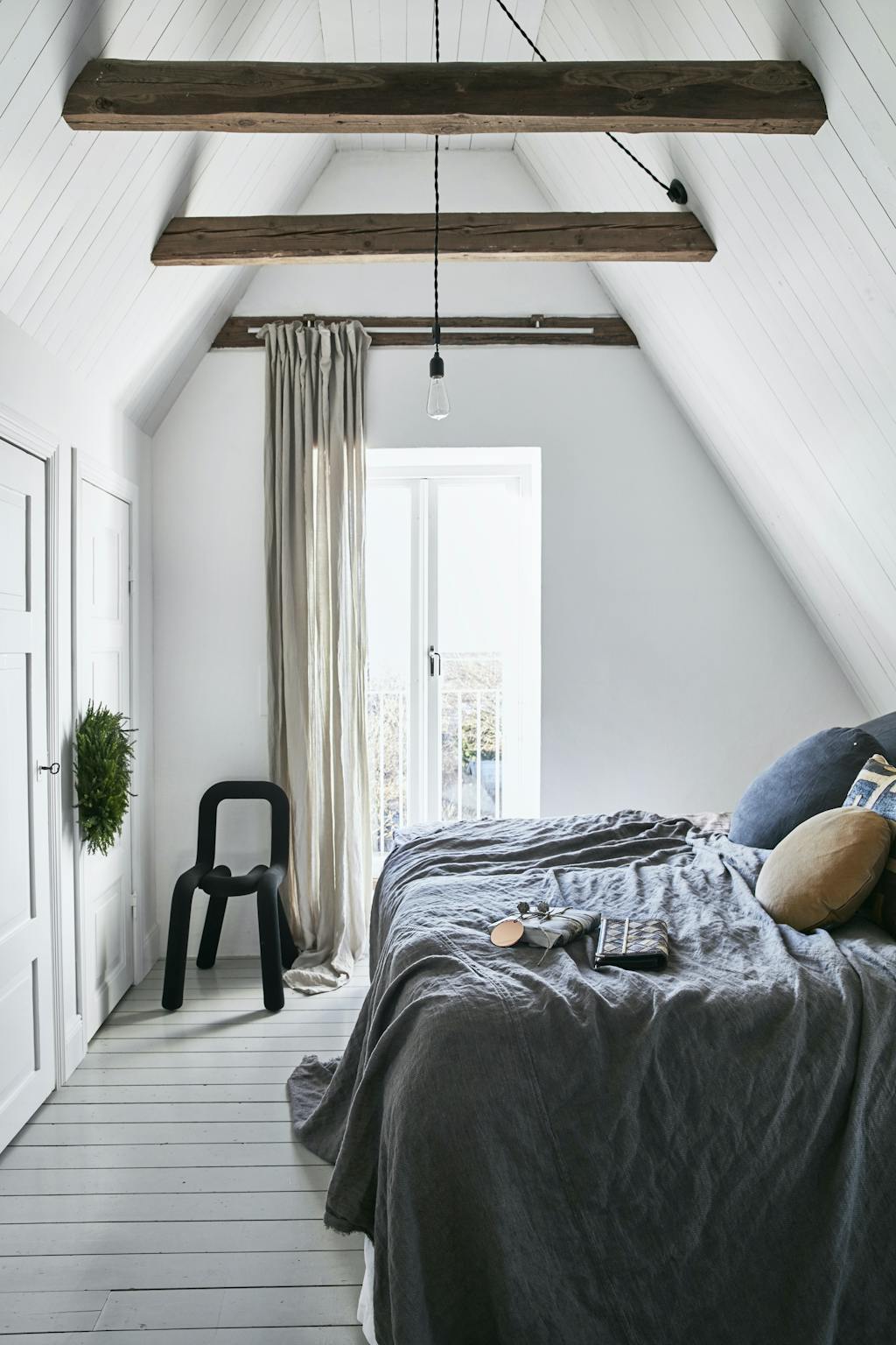 Koselig soverom med bjelker i taket. 