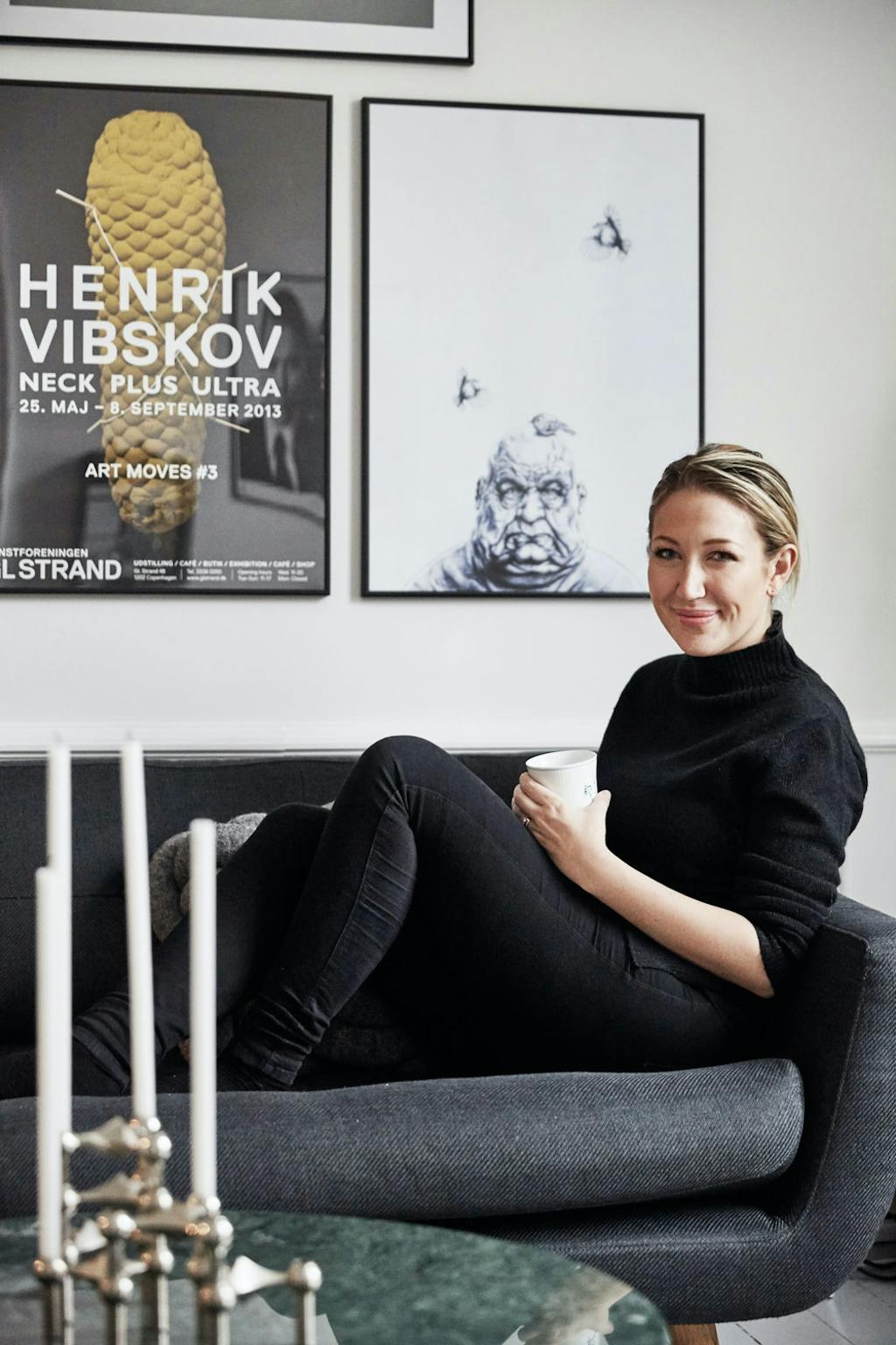 Ida Thestrup i sofaen under innrammede plakater