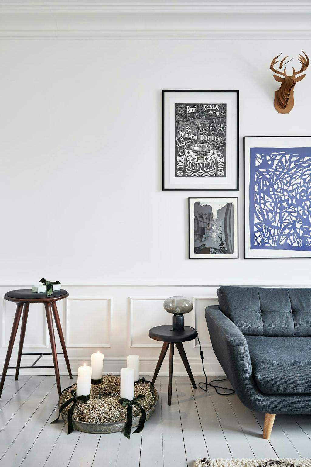 Stue med stukkatur og veggpanel, plakatkunst på veggen