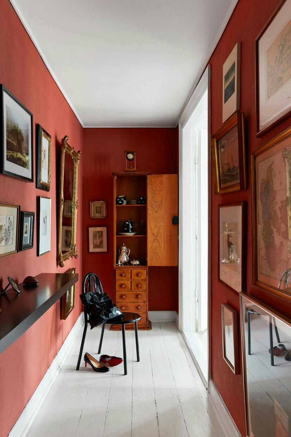 Mørk rød gang med kunst på veggene