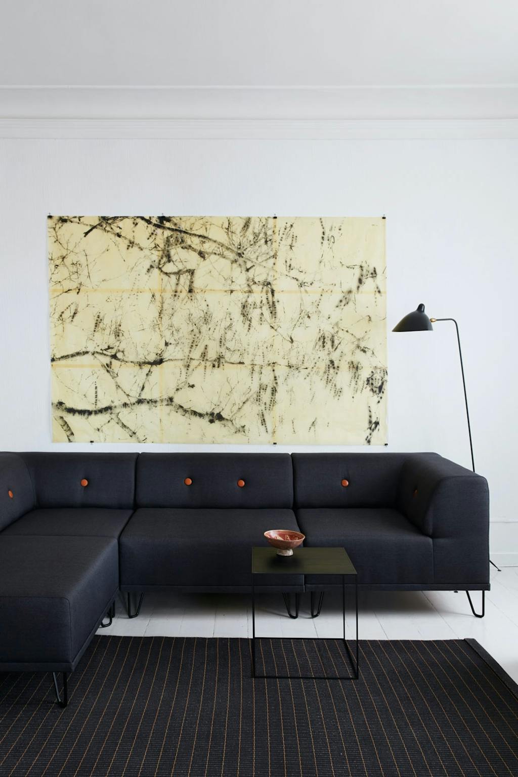 Stue med sofa fra Formel A, Serge Mouille-lampe, bod fra By Lassen og tepe fra Woodnotes.