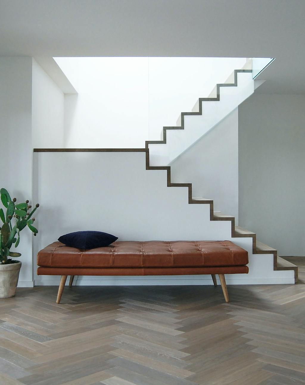Flad lædersofa i daybed-stil foran trappe