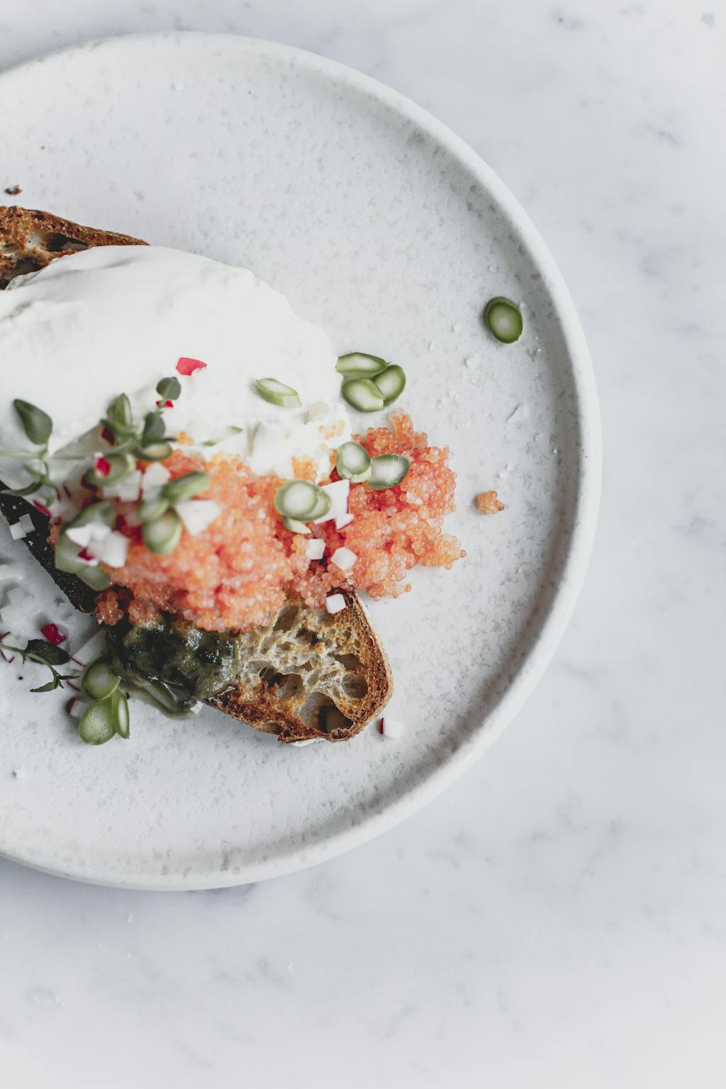 Camilla Drost fra Atelier Ea serverer toast med burrata, stenbidderrogn og ramsløg