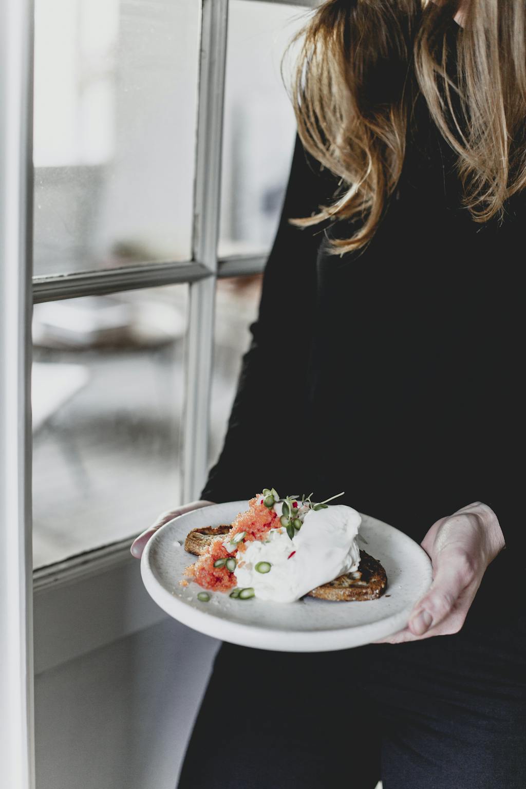 Camilla Drost fra Atelier Ea serverer toast med burrata, stenbidderrogn og ramsløg