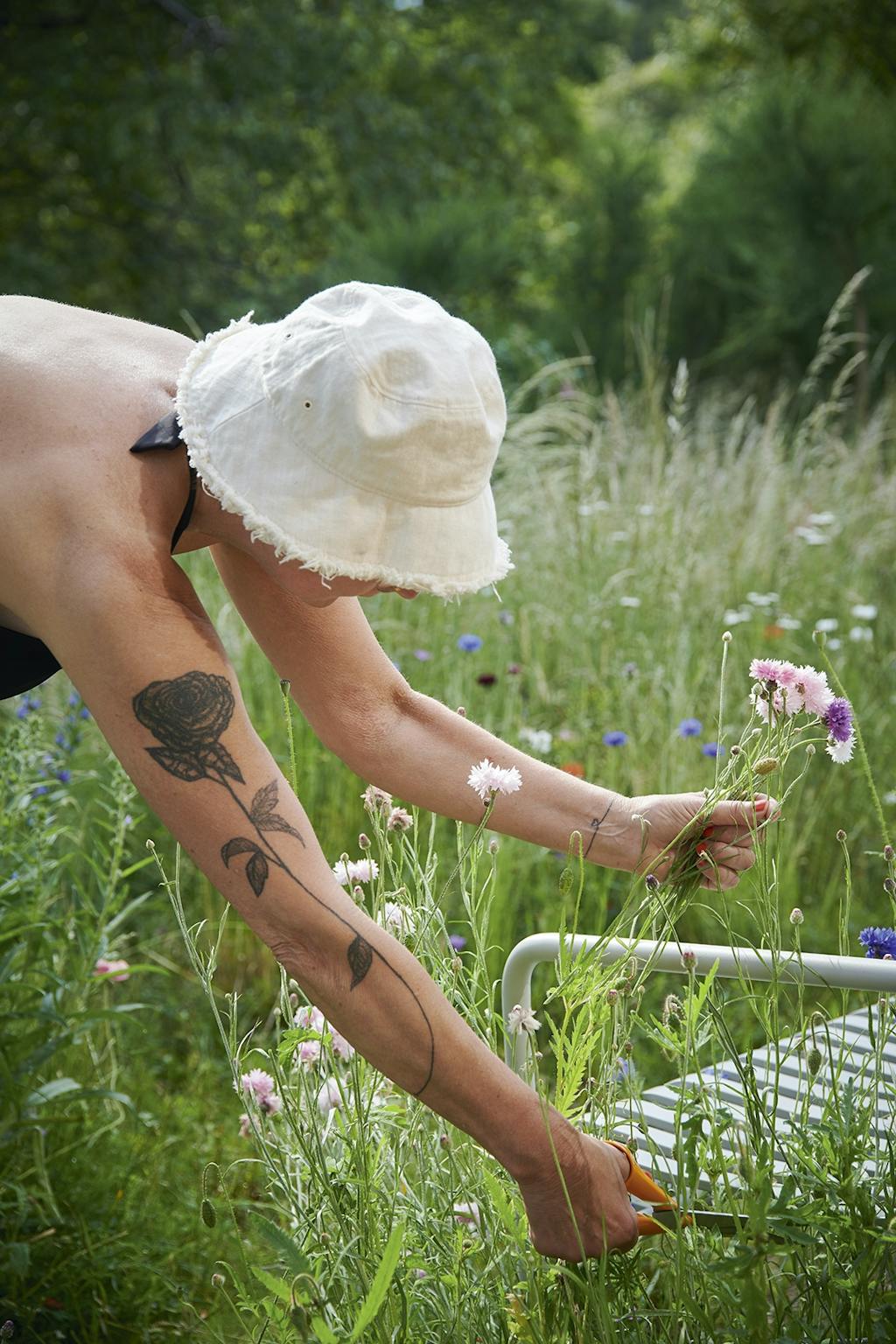 Arkitekt Karen Kjærgaard plukker nogle af de vilde blomster nær sommerhuset