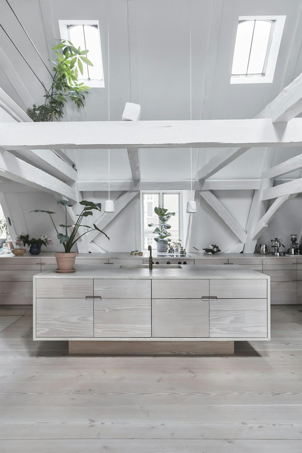 Lyst køkken med travertin-bordplade og grønne planter. Lyst køkken med travertin-bordplade og grønne planter.