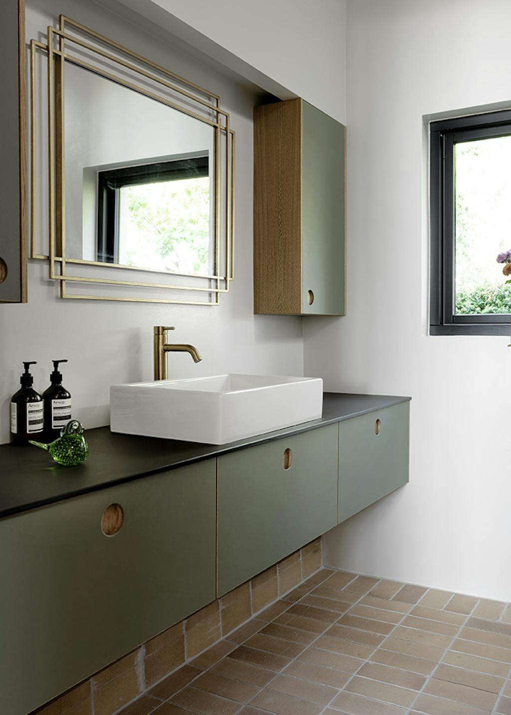 Lækkert grønt badeværelse med messingdetaljer