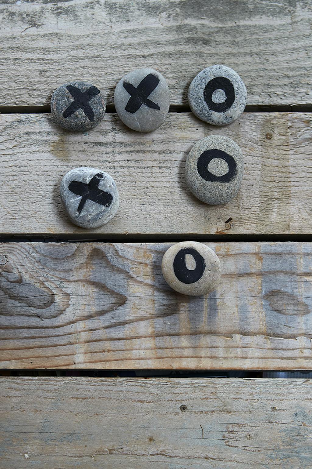 Et hjemmelavet kryds-og-bolle-spil lavet af sten