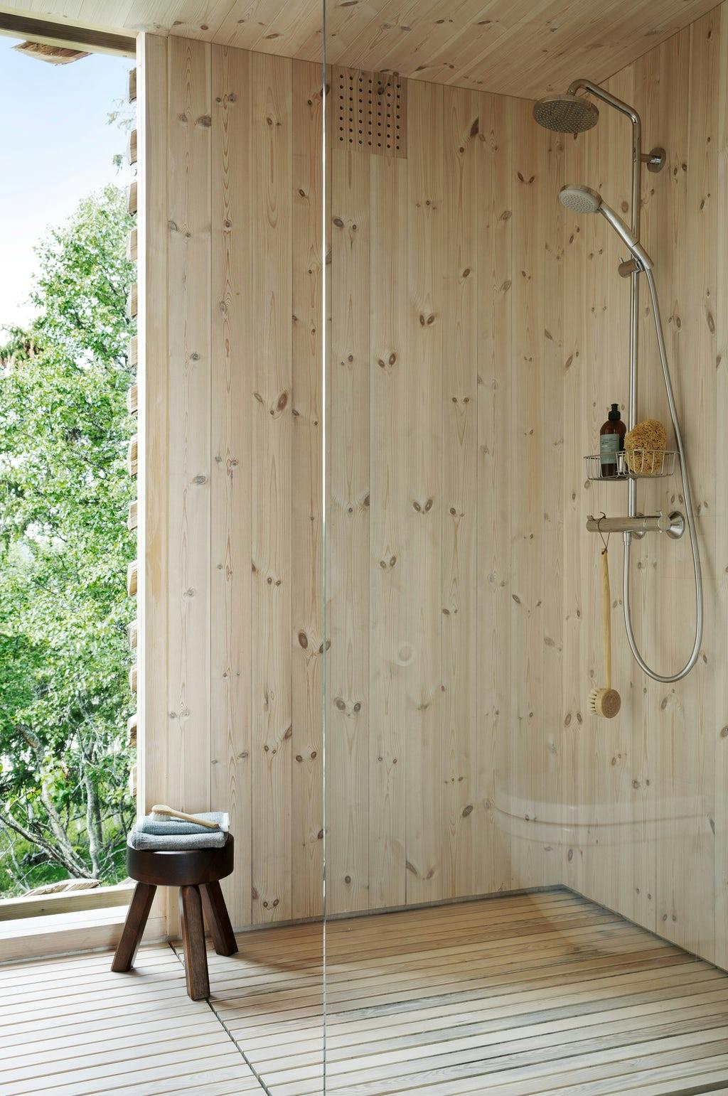 badkamer met houten wanden en uitzicht op het bos