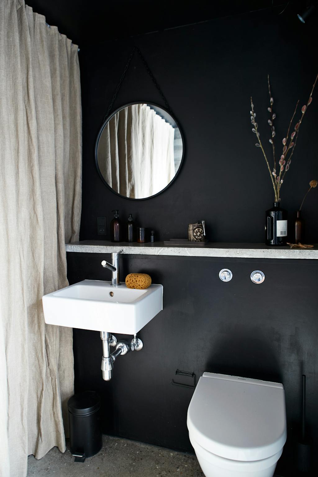 zwarte badkamer met ronde spiegel