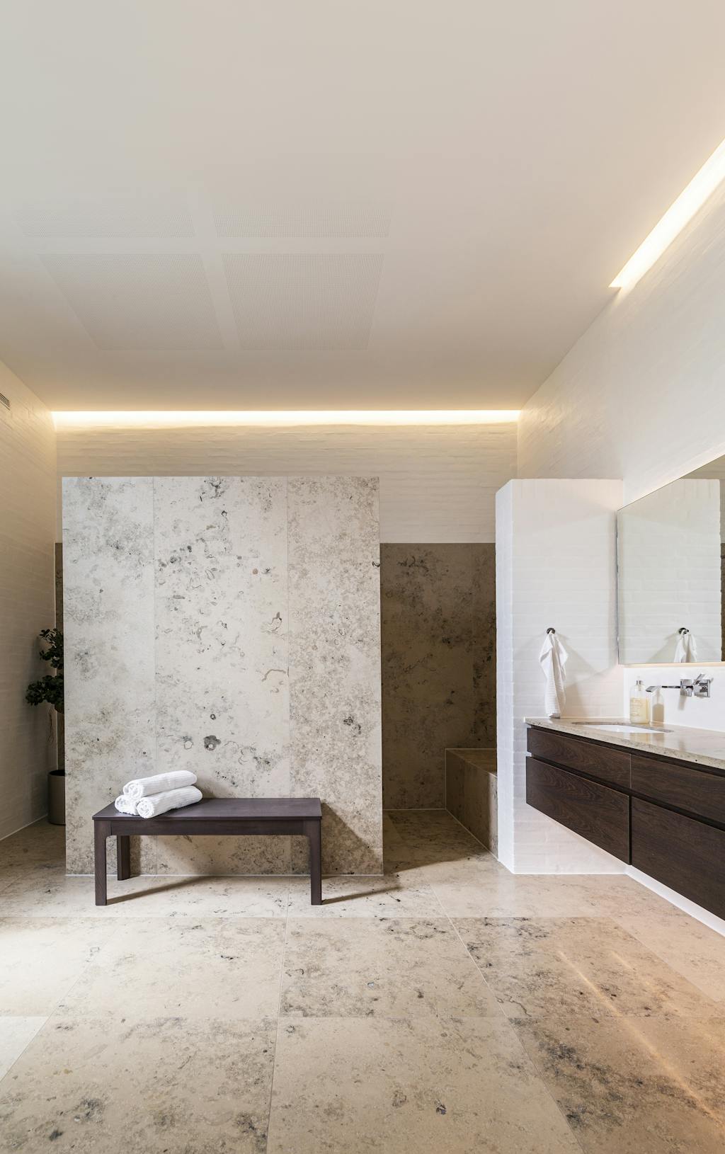 stort lyxigt badrum i marmor med mörkt trä