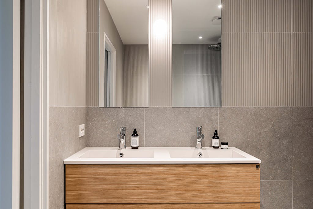 Baderom med baderomsmøbel, to servanter og speil