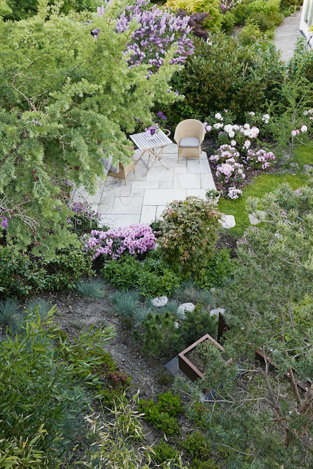 Hyggelig terrasse omgivet af blomster