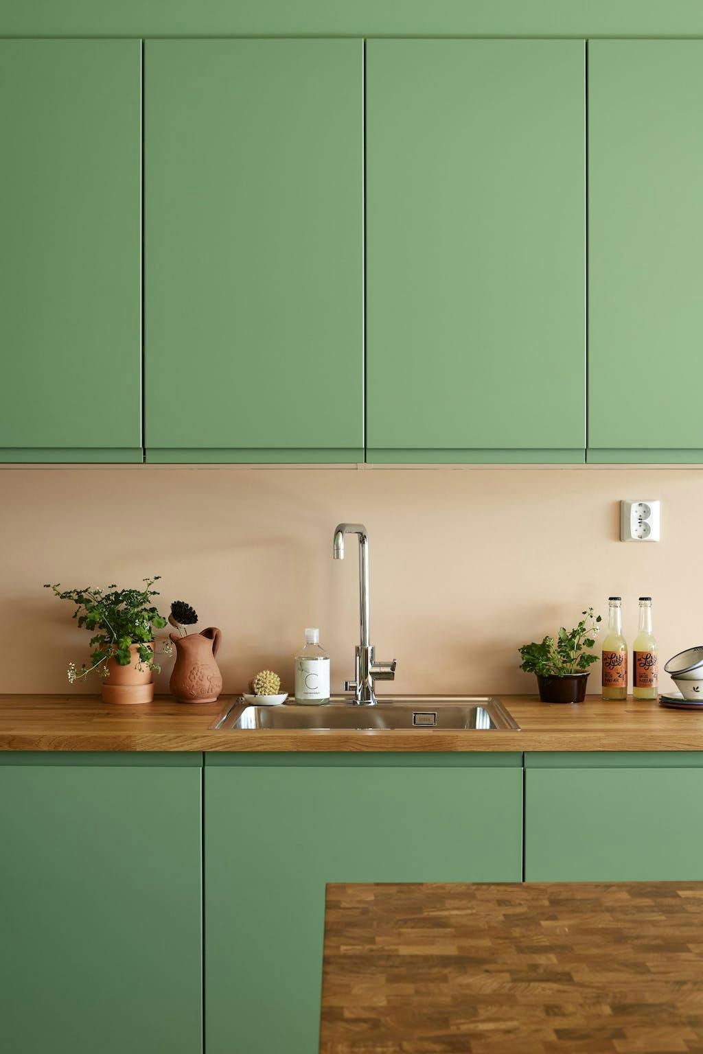 De groene keuken heeft een houten keukenblad