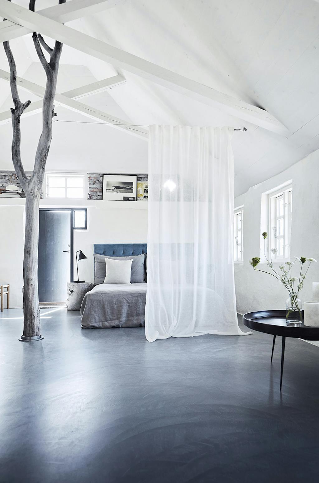 Et florlet gardin funger her som afskærmning for sengen Et florlet gardin funger her som afskærmning for sengen