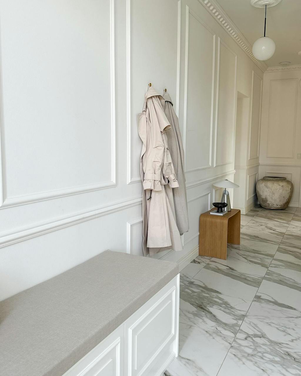 entré med vægpaneler og marmorklinker