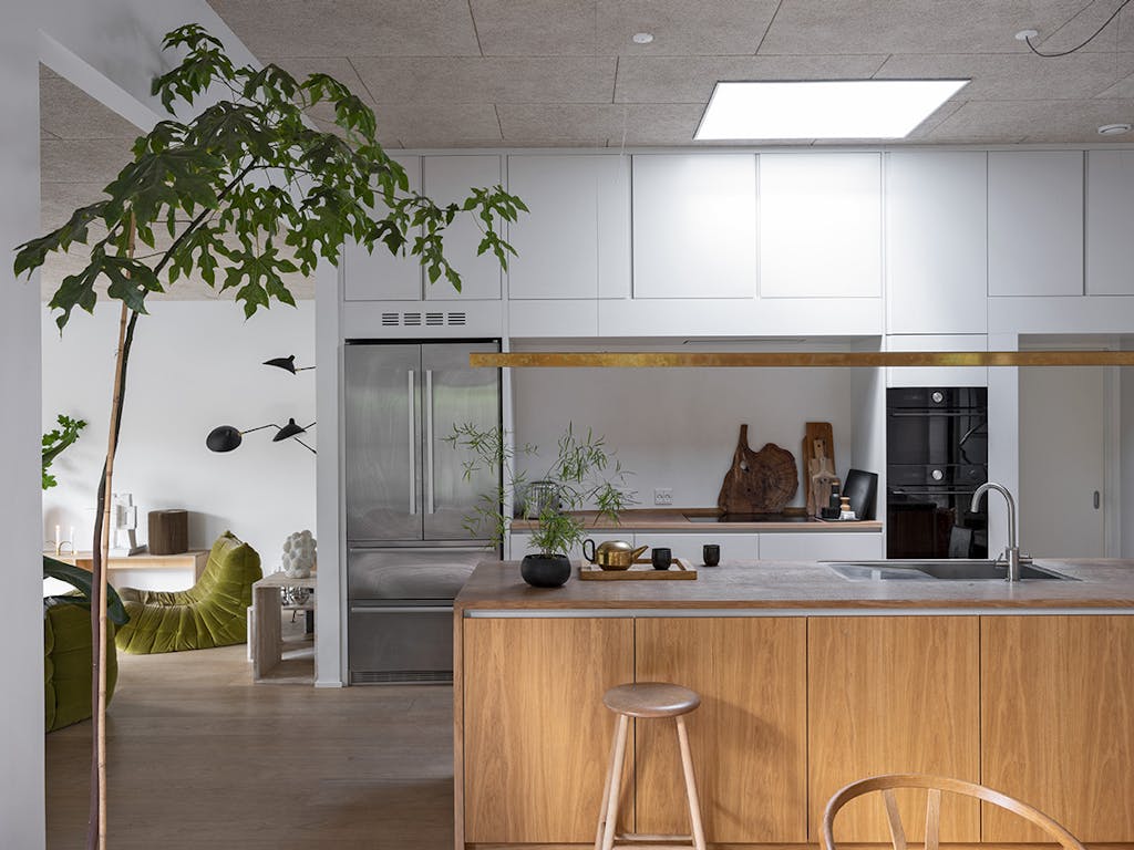 Køkken-alrum i nybygget hus med køkken i træ og lyseblå