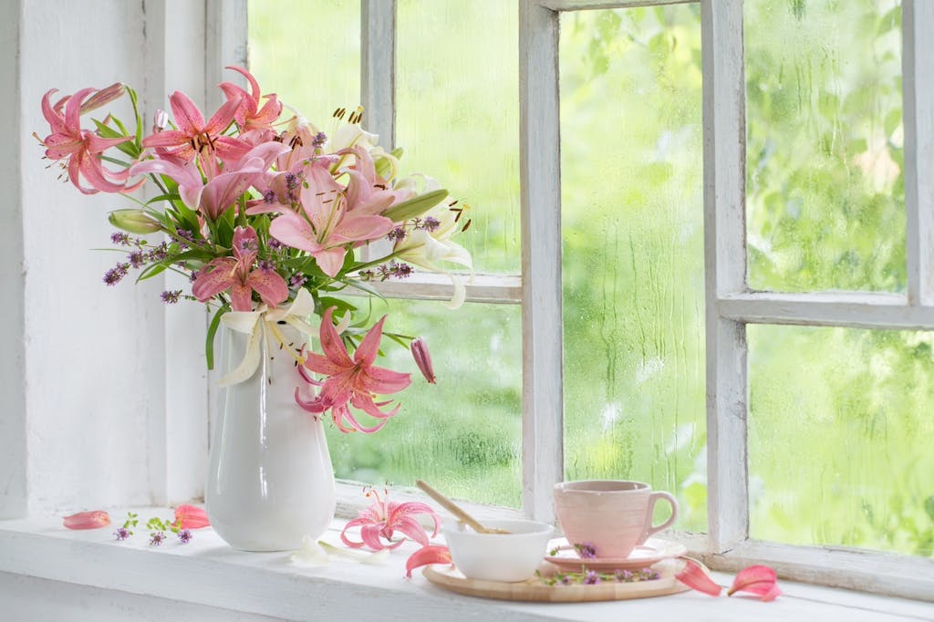 cup of tea and summer flowers on vintage windowsiil