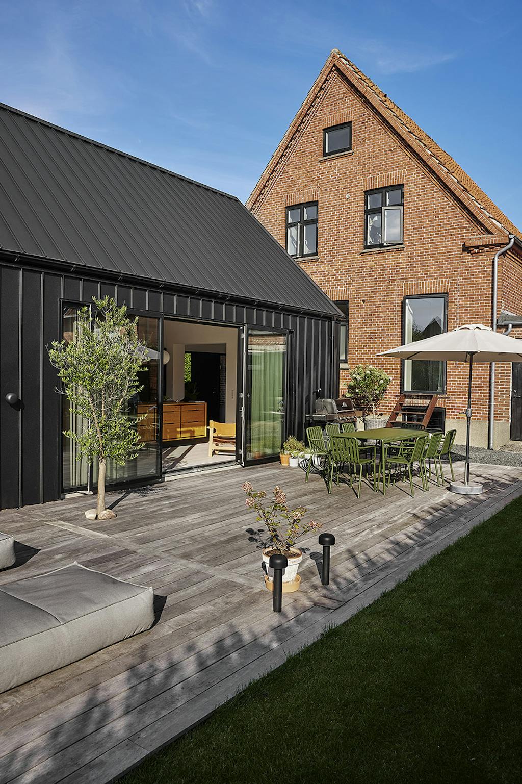 Rød murermestervilla med moderne tilbygning.