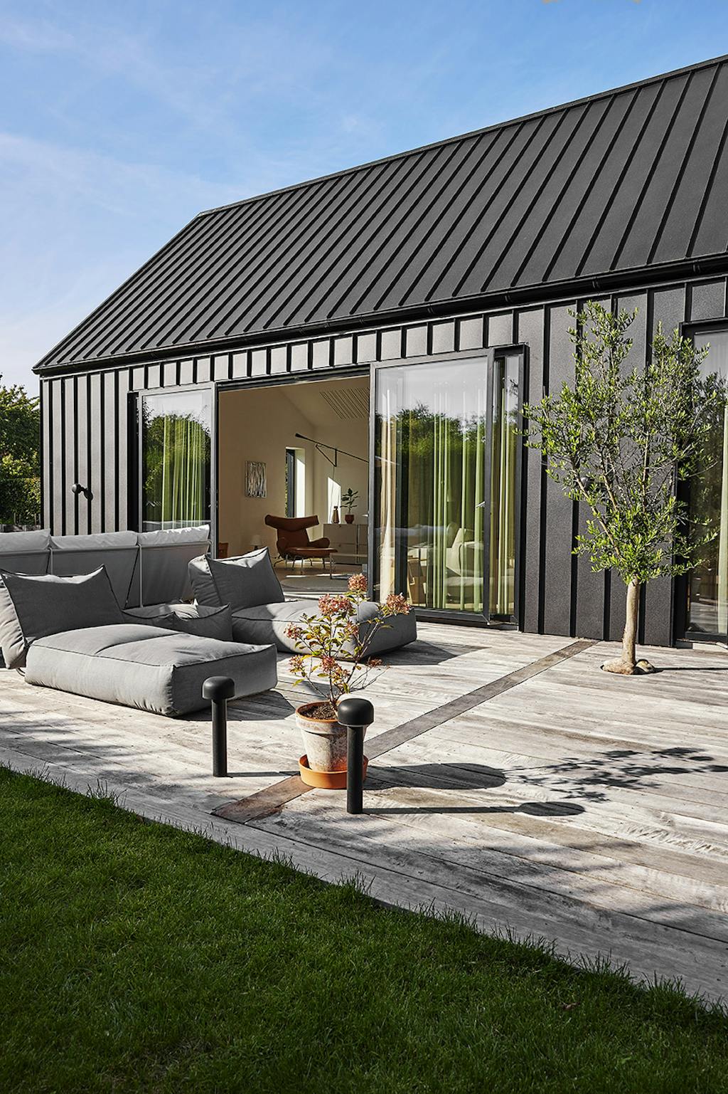 Rød murermestervilla med moderne tilbygning.