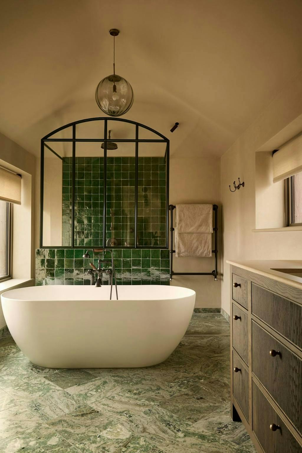 Badkamer met losstaand bad en groene tegels en marmer Badkamer met losstaand bad en groene tegels en marmer