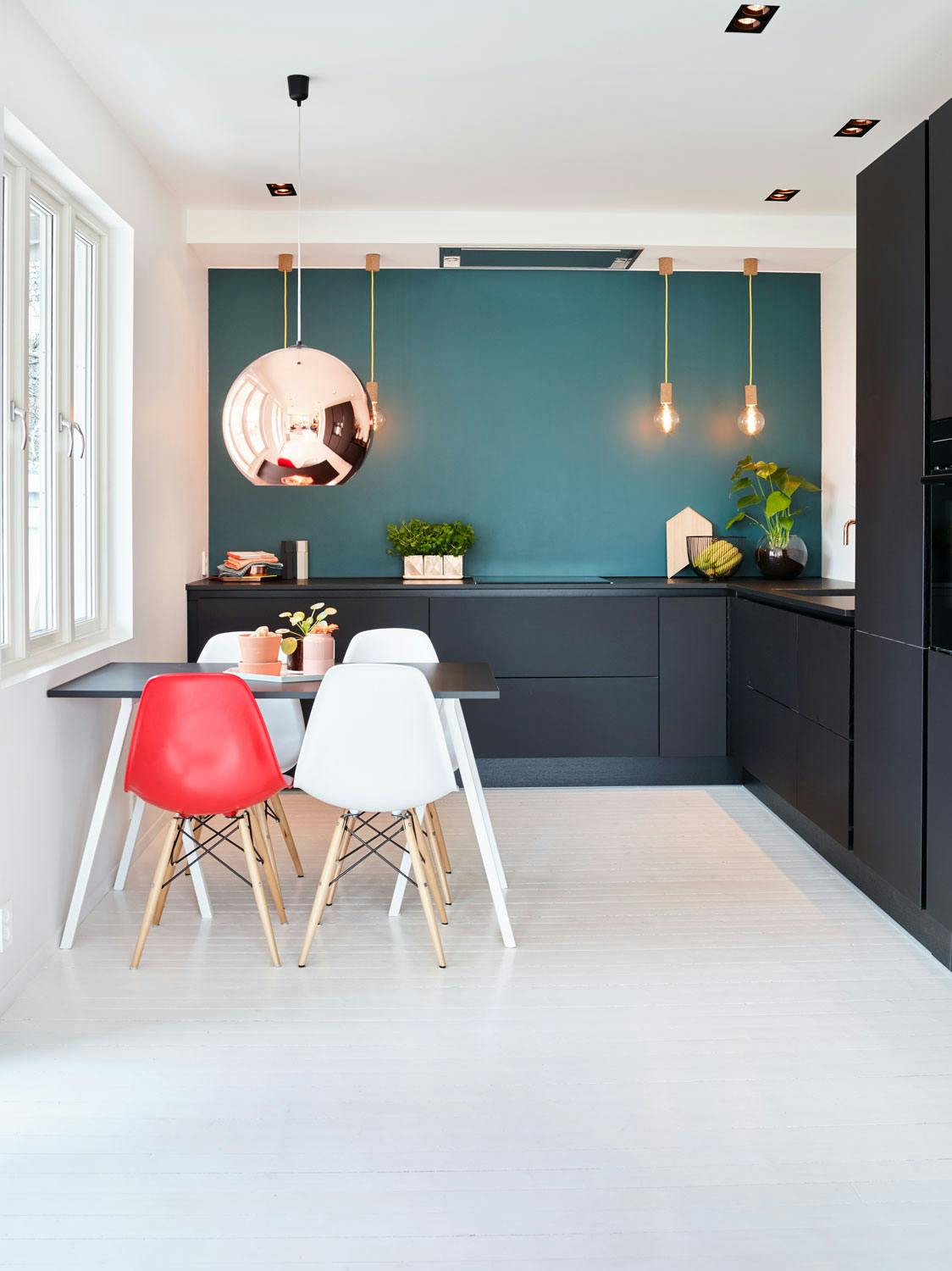 De superlekre, matte kjøkkenfrontene fra HTH står i lekker kontrast til den glitrende kobberlampen fra Tom Dixon. Spisebordet er laget med bordplate i samme materiale som benkeplaten, lagt på benbukker fra Hay. Stolene er funnet på Finn.