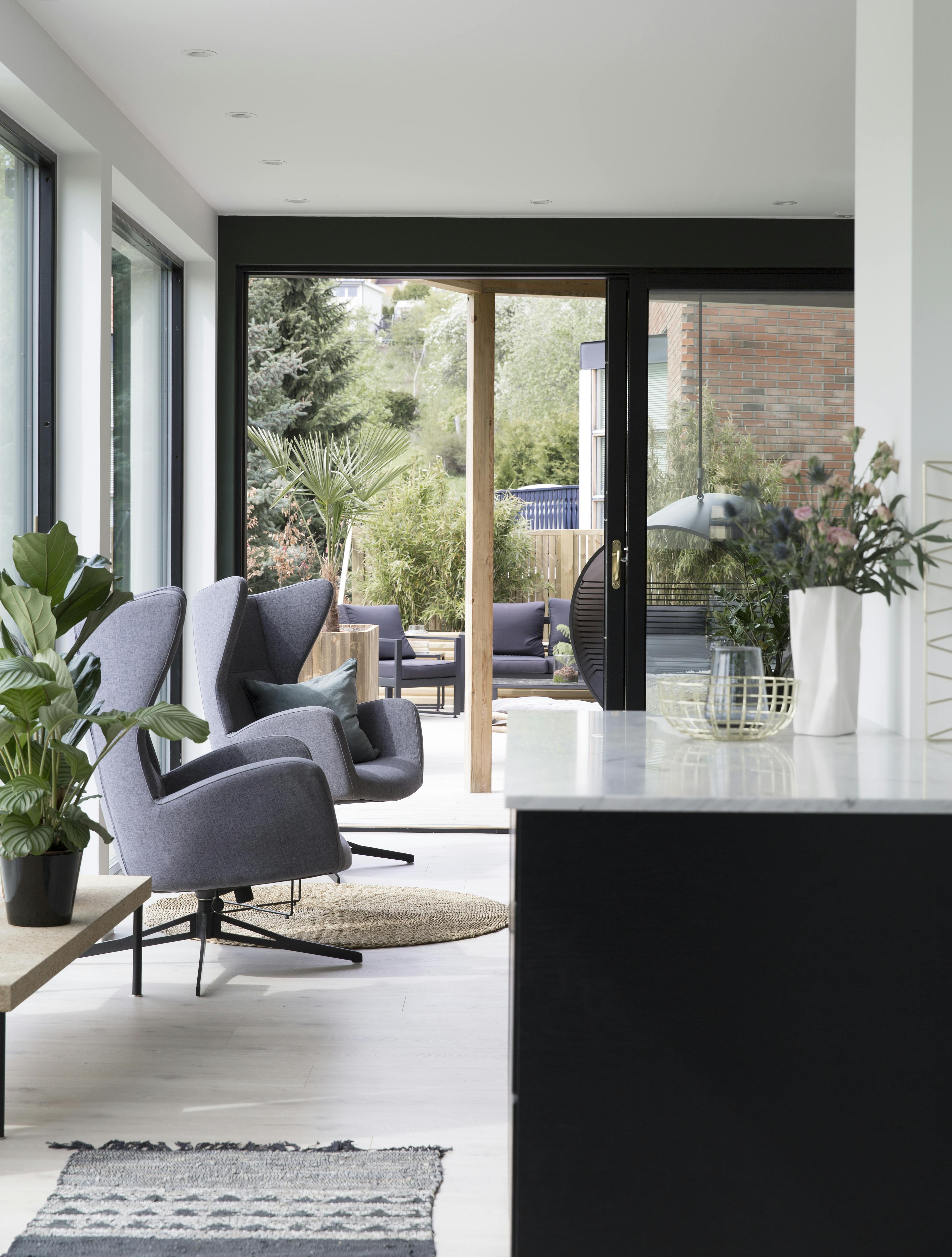 Lys funkisstue med mange vinduer 