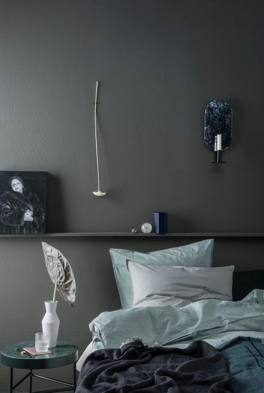 Soverom i en mørk farge med mintfarget sengetøy