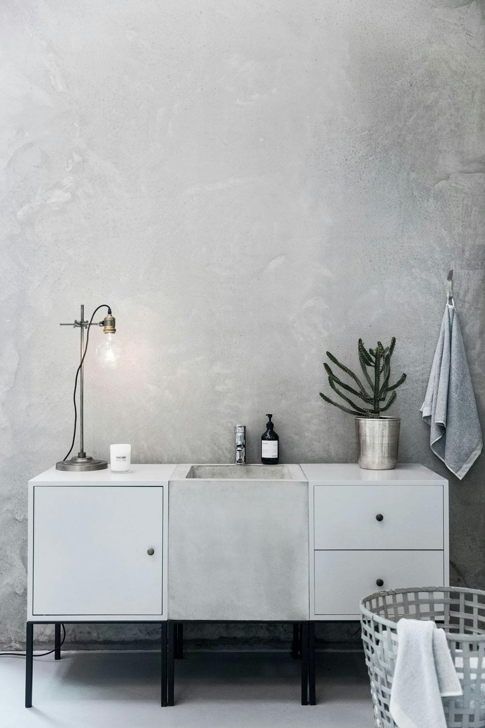 Grått møbel med skap og skuffer på hver side av en betongvask