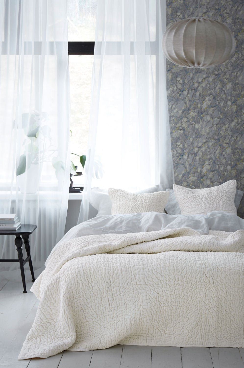 Lyst og deiilg soverom med fin tapet