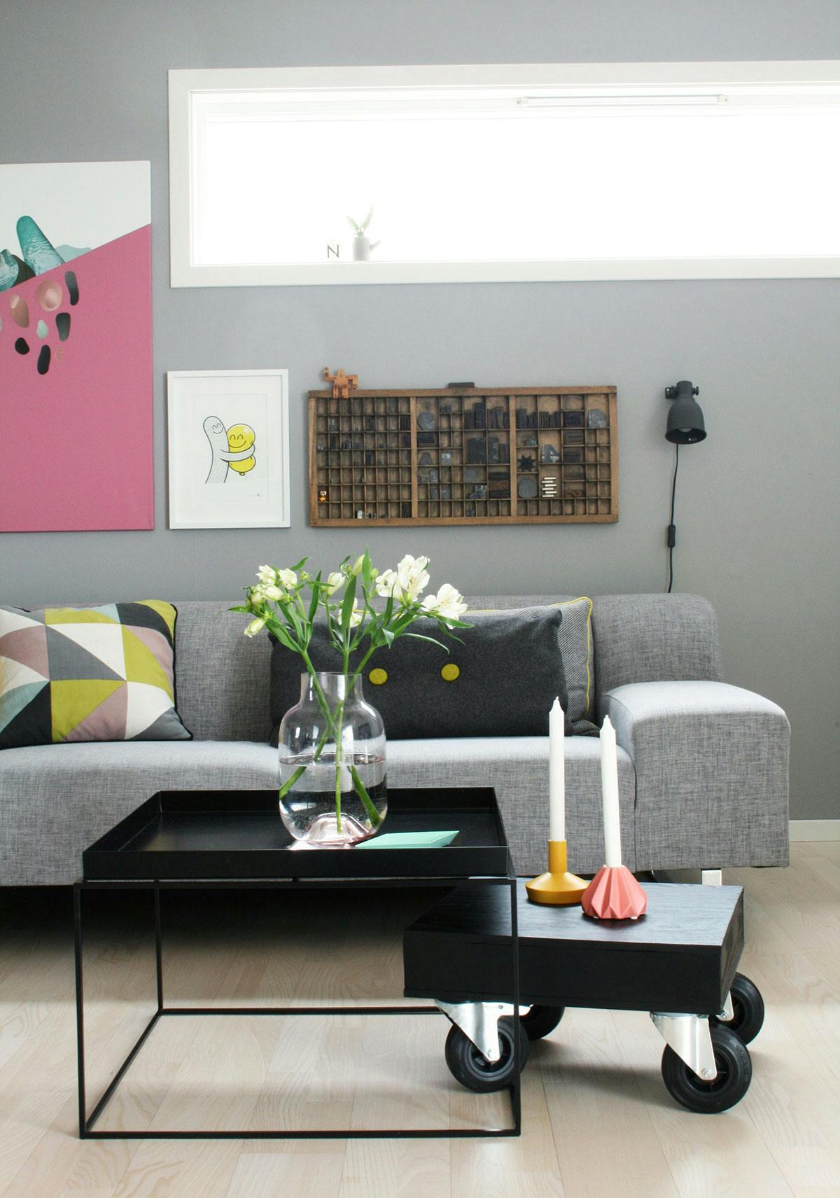 Over sofaen henger settekassen Gry fikk av sin tidligere arbeidsgiver. Foran står et sofabord fra Hay og et DIY-bord mannen har laget.